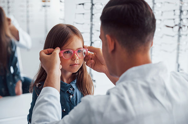 child trying on eyeglasses